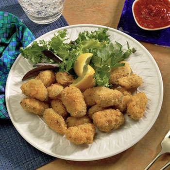 A plate of fried panko breaded mussels with a side of cocktail sauce. www.seatechcorp.com