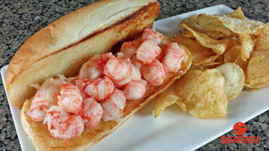A photograph of a butter boached langostino lobster roll.