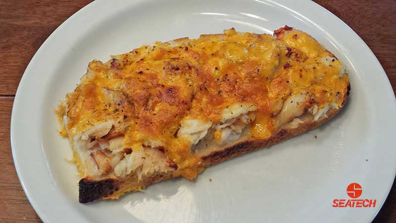 A photograph of a Chilean crab meat melted cheese open face sandwich.