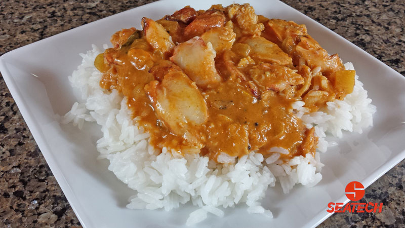 A photograph of Chilean crab meat and red Indian curry sauce over rice.