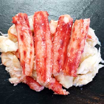 A photograph of Chilean king crab meat with vibrant red merus meat over pure white body meat.