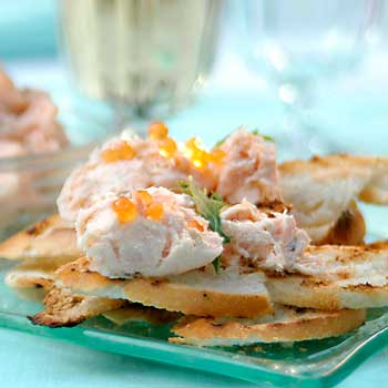 A photograph of cooked salmon spread on toast with salmon roe.
