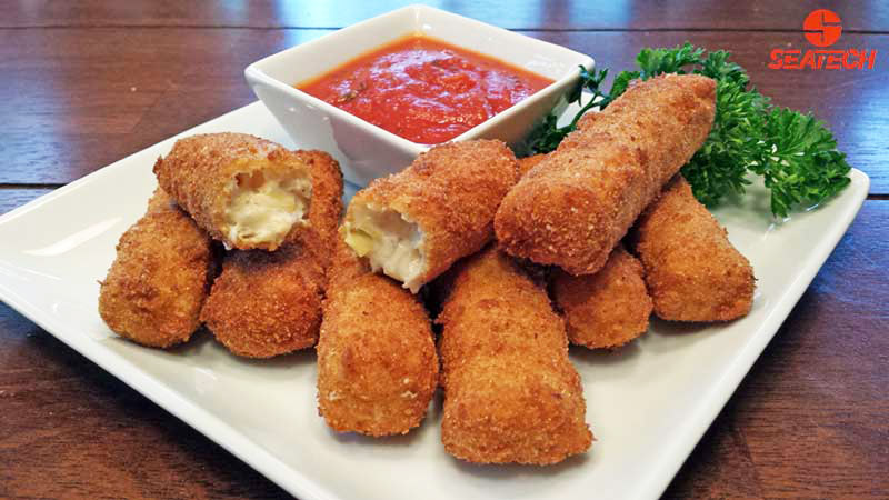 A photograph of crab cheese sticks on a plate with manara sauce featuring seatech crab meat.