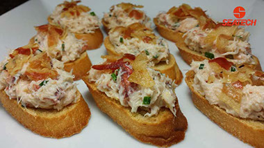 A plate with crab bruschetta topped with crisp pancetta.
