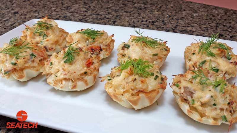 Phyllo cups stuffed with crab meat, cheese, cream cheese and chives with a fresh dill garnish.