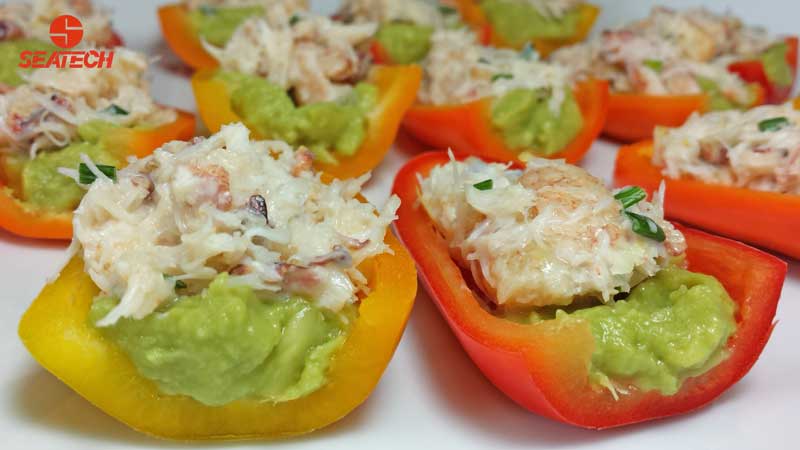 A photograph of mini sweet bell peppers stuffed with crab salad and guacamole