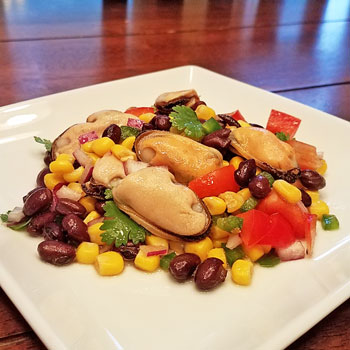 Mexaican mussel salad with mussels, black beans, corn, red pepper, jalapeno peppers, cilantro, olive oil and lime juice.